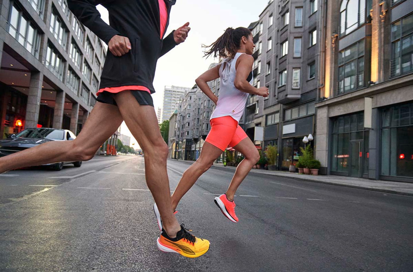 Man in woman running in an urban setting in PUMA running shoes