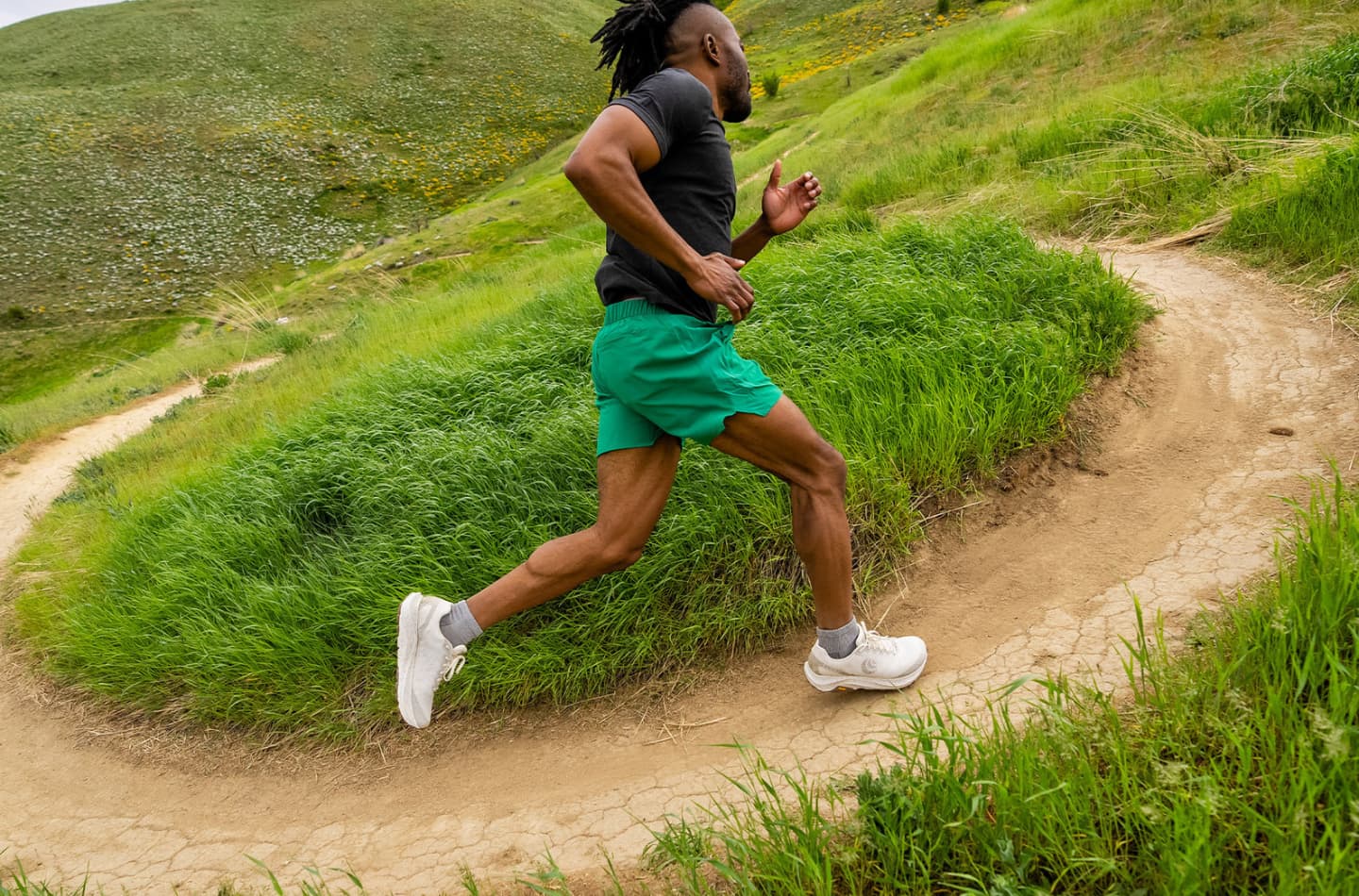 Man running on a trail in Topo trail running shoes