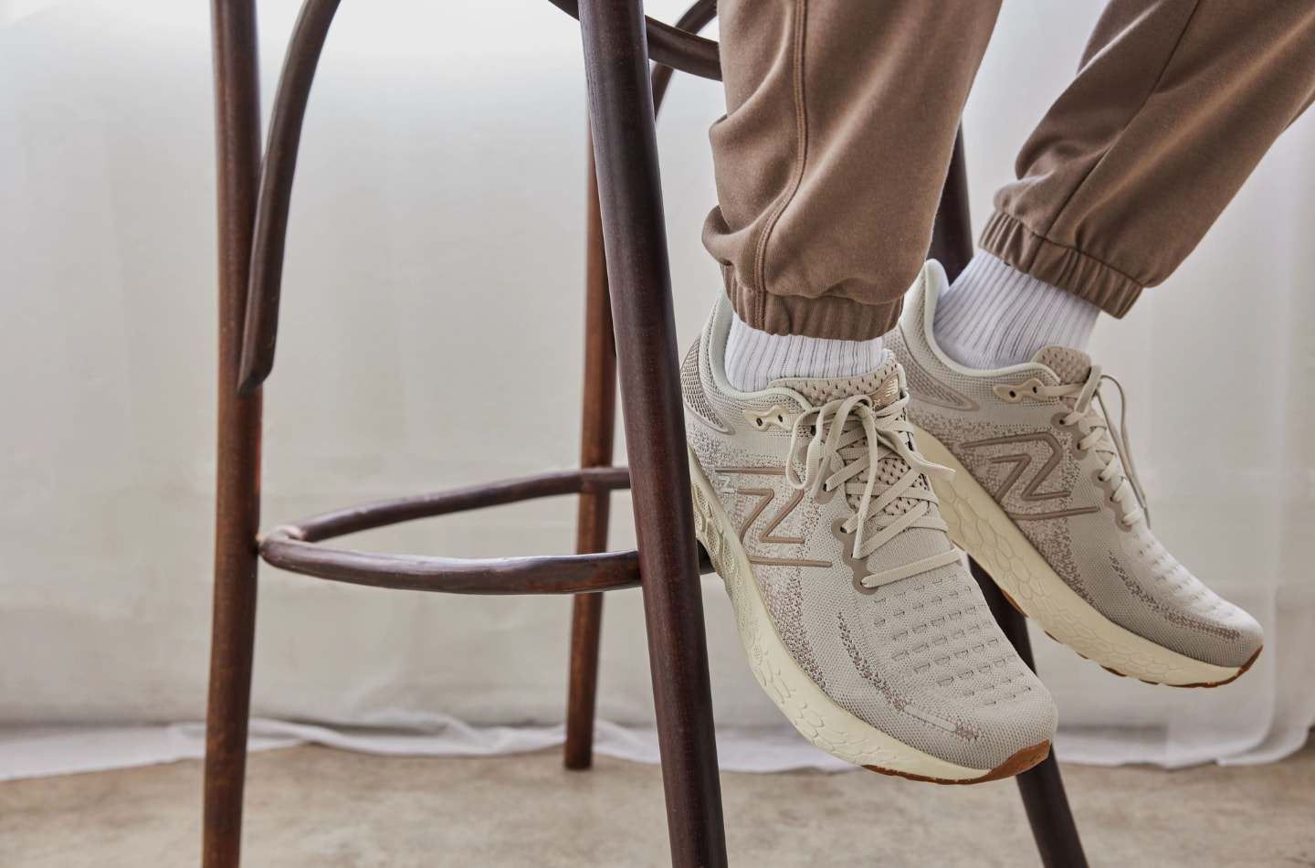 Man sitting on a stool wearing the New Balance 1080v12